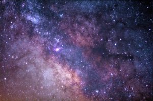 dark purples of the sky, the cosmos, splotches of brighter and darker colors, almost like a watercolor painting