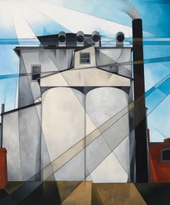 Painting by Charles Demuth of grain silos, the structures are light grey, there are streaks of white in a blue sky above it that look like they might mean to be sunbeams