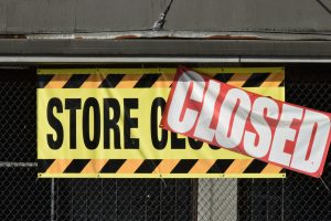 sign on a storefront that says store closed